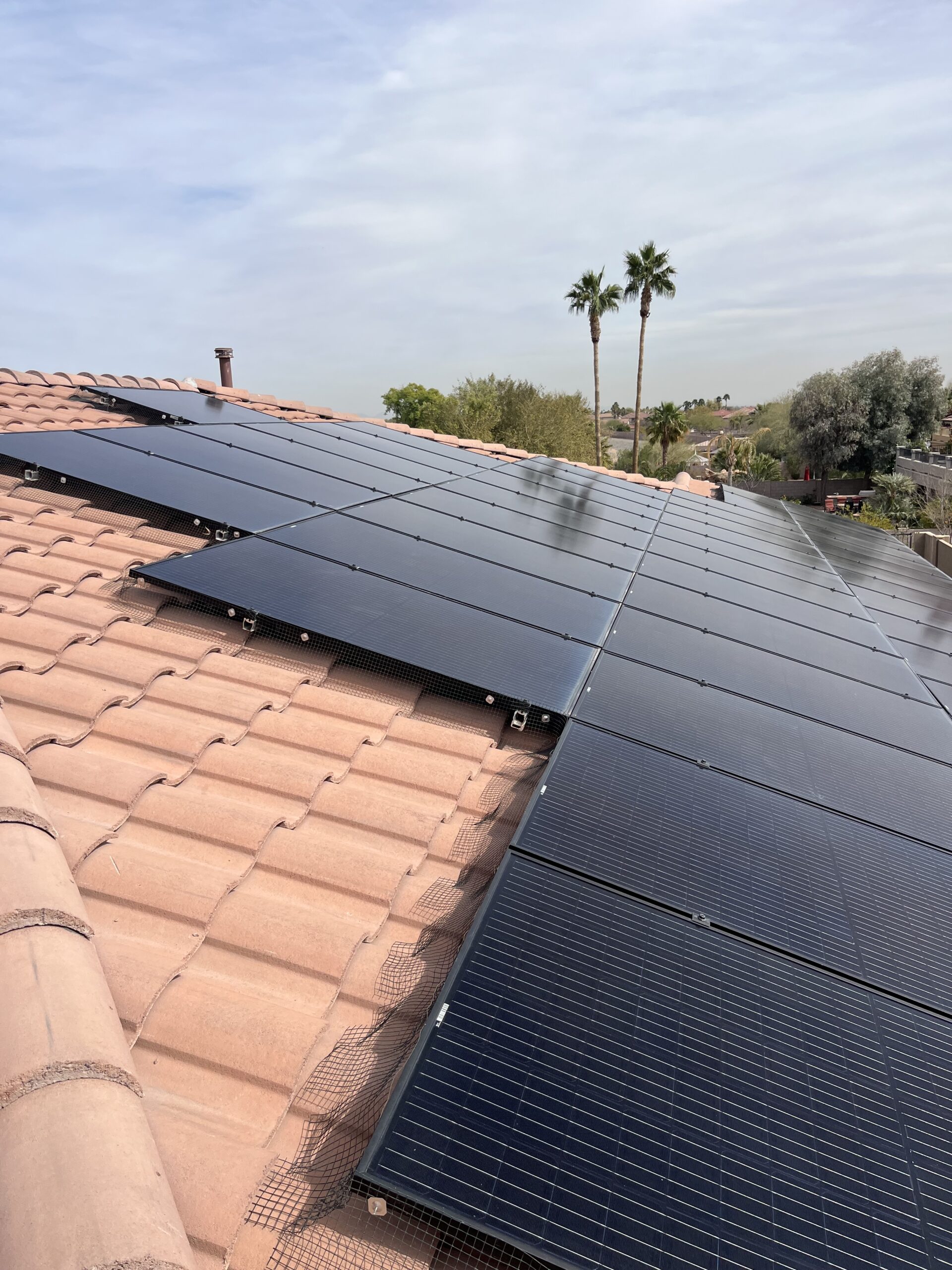 Attaching clips to secure mesh while installing solar panel bird guard kits.